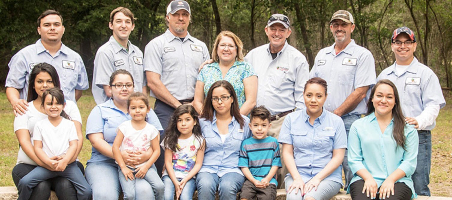 The full Gulf Coast Exterminators team and their families outdoors in Houston